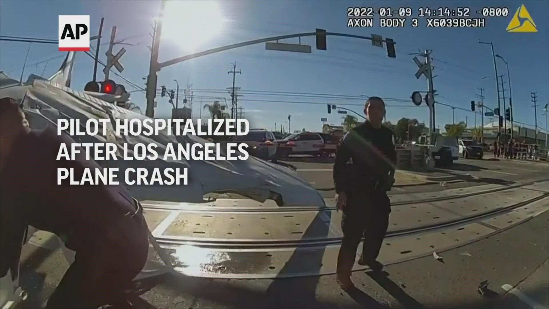 The video shows officers rescuing the pilot of a downed plane that had crashed onto train tracks near L.A.