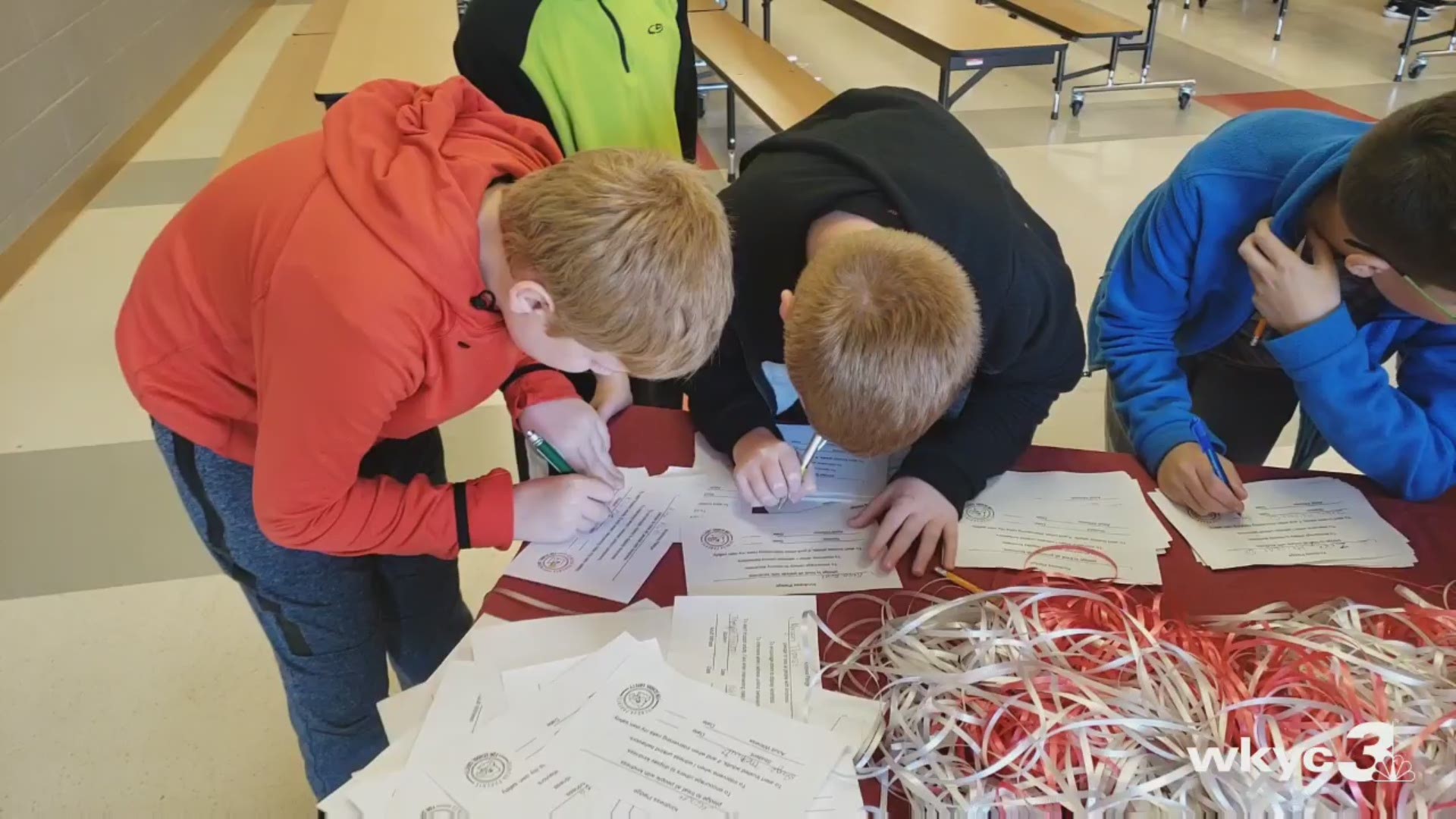 Students at Geneva Middle School are signing kindness pledges and tying ribbons to a fence outside as a symbol of that pledge. This event is occurring as part of National Bullying Prevention Month.