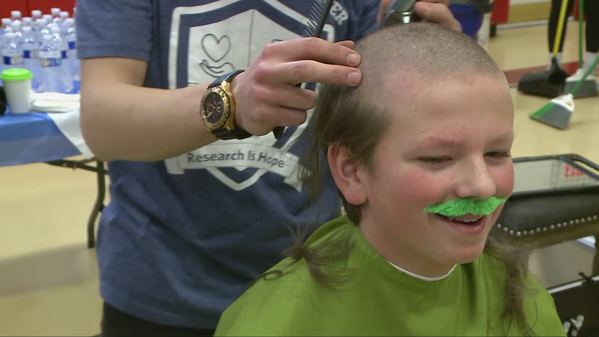 The head-shaving event drew nearly 100 people at the school.