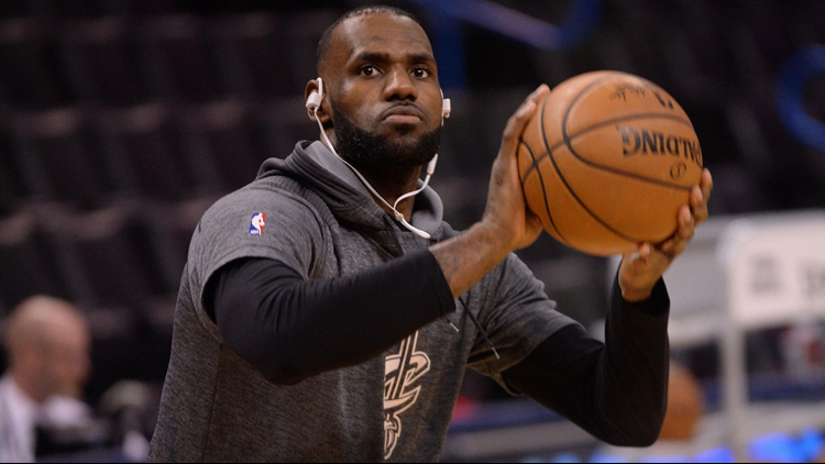Cleveland Cavaliers' LeBron James throws a backhand pass between
