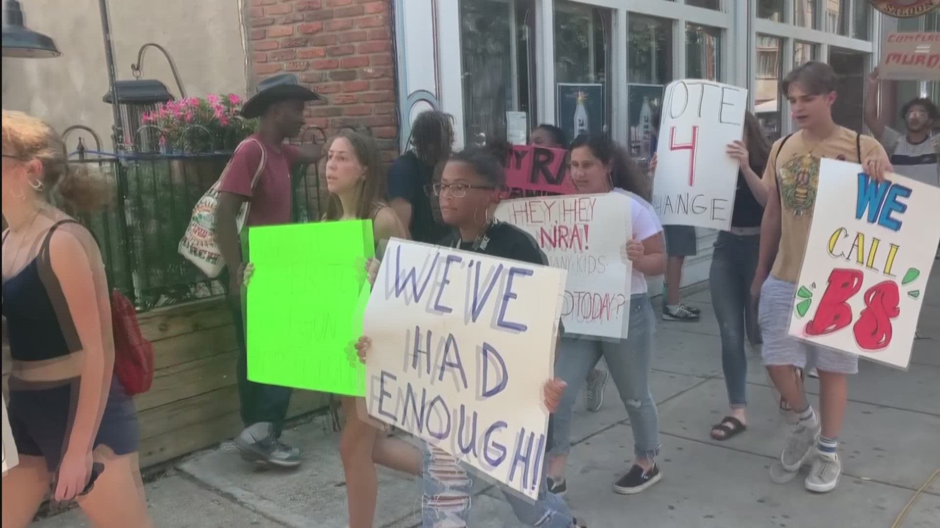 A group of young people march down the sidewalks of Dayton in the aftermath of Sunday's mass shooting
