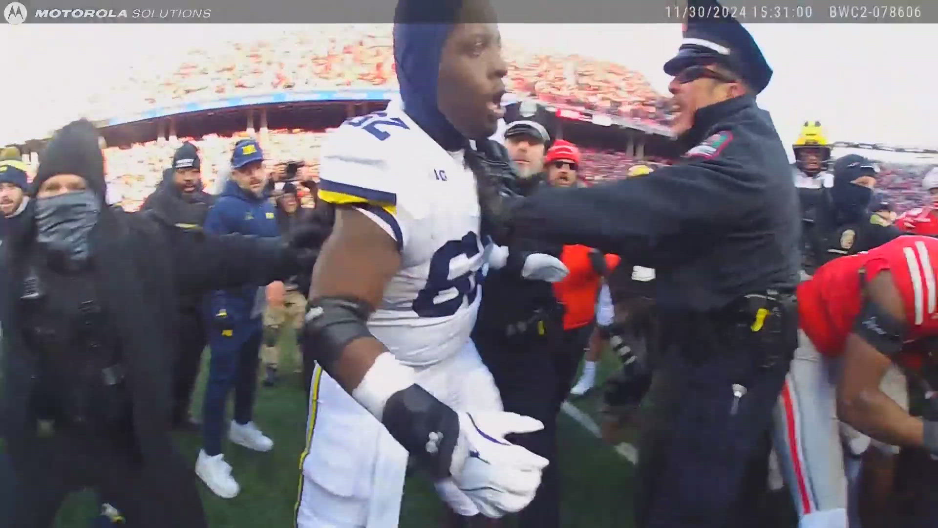 Dozens of officers are seen rushing onto the field trying to get players and staff off each other.