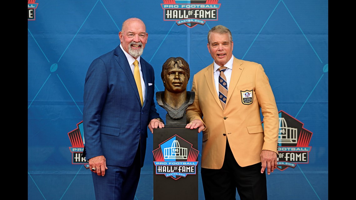 Scott Howley poses with the bronze bust of his father, Chuck