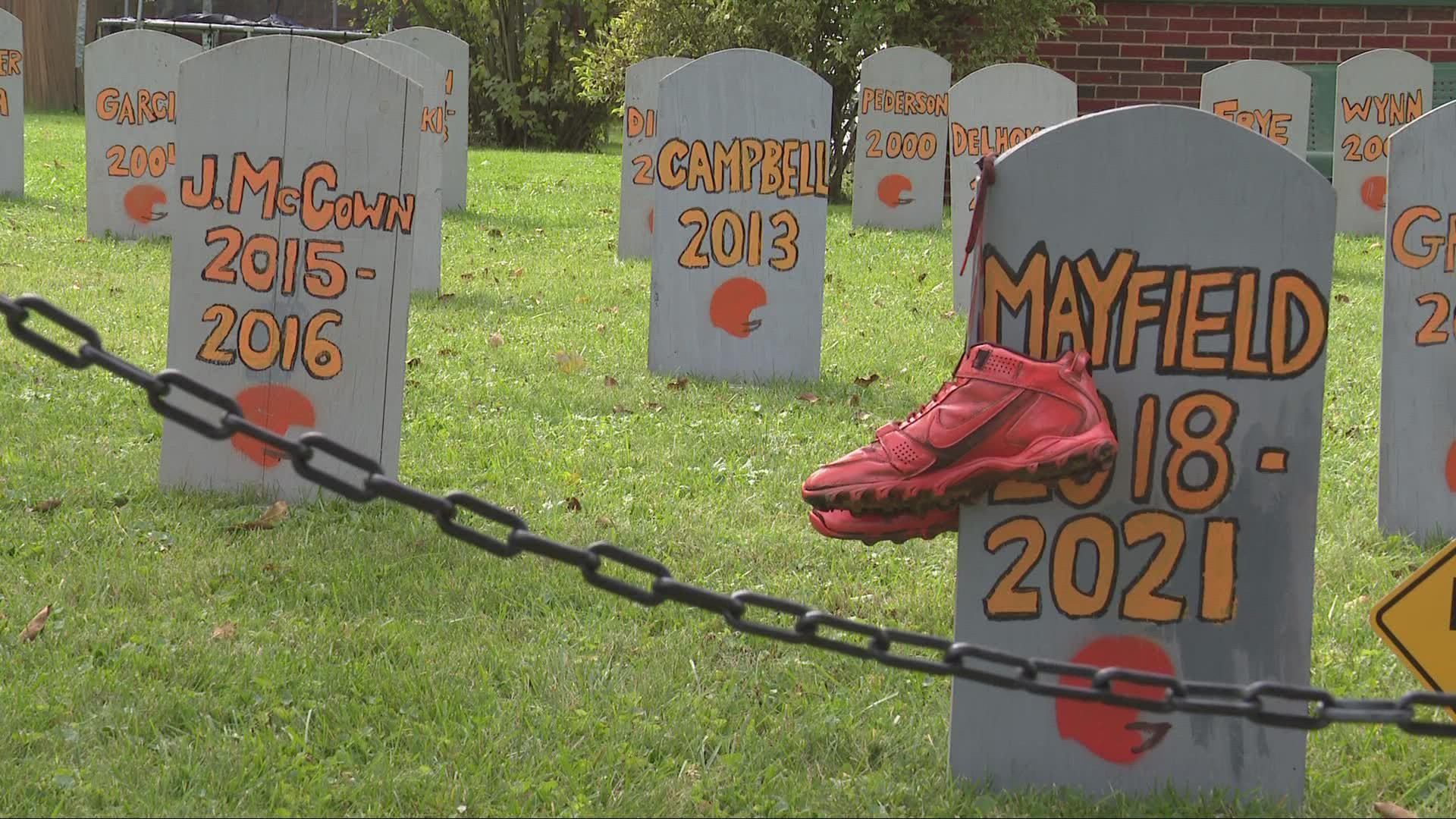 Each tombstone is marked with a quarterback's name and the years they played for the team written in bright orange colors.