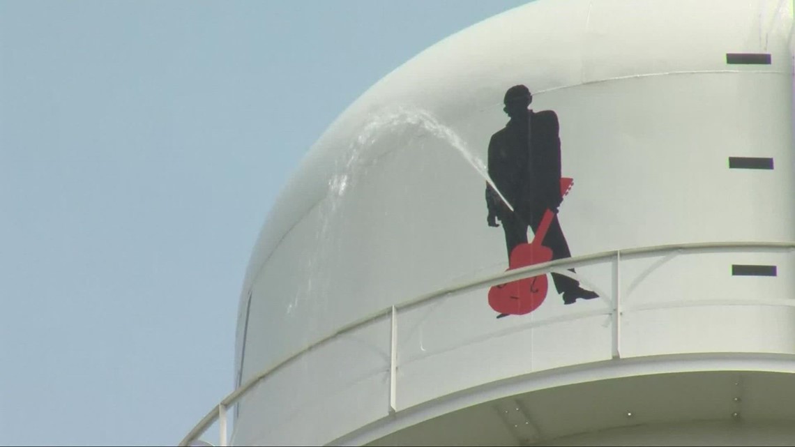 Johnny Cash silhouette on water tower appears to be urinating after springing leak